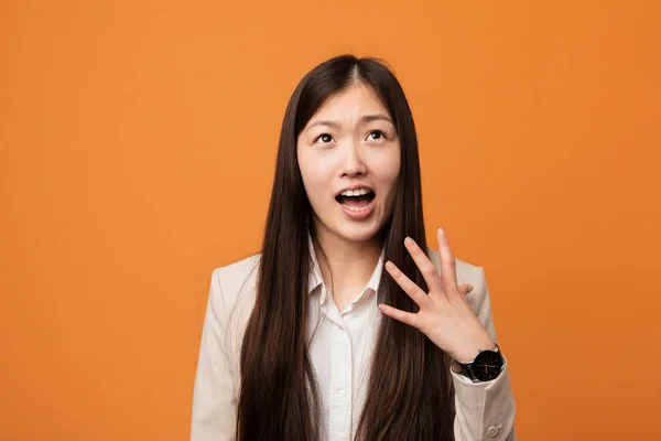 Young business chinese woman screaming with rage.