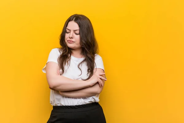 Young curvy plus size woman frowning face in displeasure, keeps arms folded.
