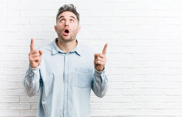 Young Handsome Man Bricks Wall Pointing Upside Opened Mouth — Stock Photo, Image