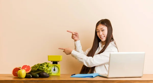Jovem Nutricionista Mulher Chinesa Trabalhando Com Seu Laptop Animado Apontando — Fotografia de Stock