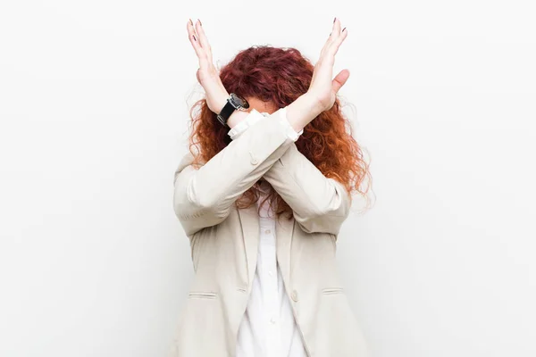 Young natural redhead business woman isolated against white background keeping two arms crossed, denial concept.