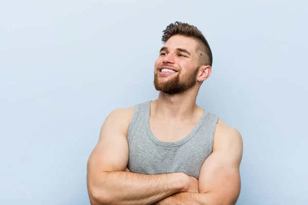 Giovane Bel Fitness Uomo Sorridente Fiducioso Con Braccia Incrociate — Foto Stock