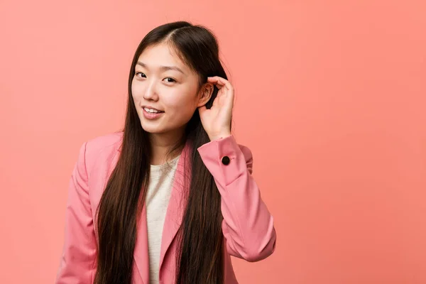 Νεαρή Κινέζα Επιχειρηματίας Που Φοράει Ροζ Κοστούμι Προσπαθώντας Ακούσει Κουτσομπολιό — Φωτογραφία Αρχείου