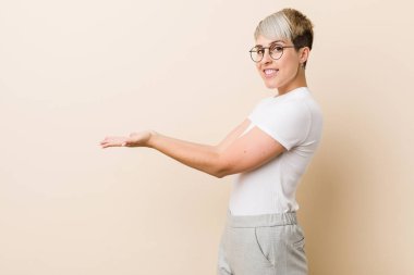 Bir avuç üzerinde bir kopya alanı tutan beyaz bir gömlek giyen genç otantik doğal kadın.