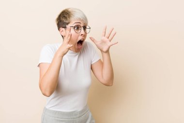 Beyaz gömlek giyen genç otantik doğal kadın yüksek sesle bağırır, gözleri açık tutar ve eller gergin.