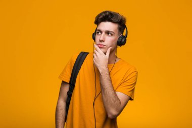 Genç serin öğrenci adam kulaklık ile müzik dinleme uzanmış el dur işareti gösteren, sizi engelleyen.