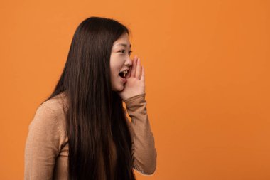 Genç güzel Çinli kadın bağırıyor ve tutan palmiye yakın açılan ağız.