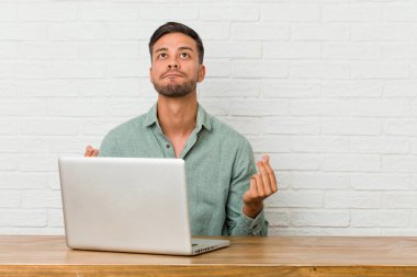 Genç Filipino adam oturan çalışma ile onun laptop gösteren o yok para.