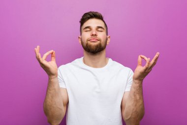 Genç yakışıklı beyaz adam zor iş gününden sonra rahatlar, o yoga yapıyor.