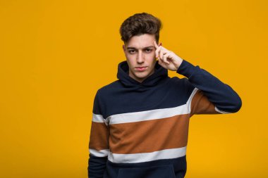 Genç serin adam parmak ile tapınak işaret kapüşonlu giyen, düşünme, bir görev üzerinde duruldu.