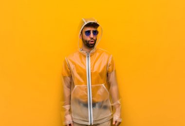 Bir fikir hakkında düşünen bir yağmur ceket giyen genç adam