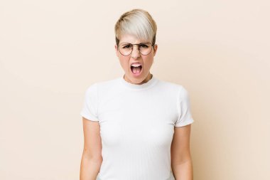 Genç otantik doğal kadın çok kızgın ve agresif çığlık beyaz bir gömlek giyiyor.