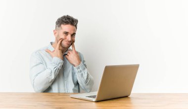 İki seçenek arasında onun laptop şüphe ile çalışan genç yakışıklı adam.