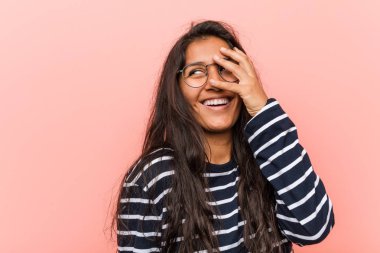 Genç entelektüel hintli kadın parmakları ile kameraya göz kırptı, yüz kapsayan utandım.