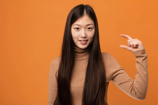 Young Pretty Chinese Woman Holding Something Little Forefingers Smiling Confident — Stock Photo, Image
