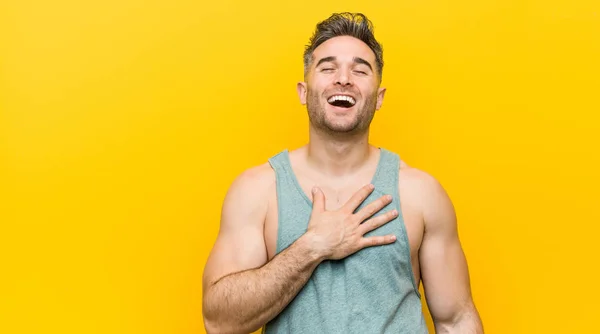 Νεαρός Άνθρωπος Fitness Ένα Κίτρινο Φόντο Γελάει Δυνατά Κρατώντας Χέρι — Φωτογραφία Αρχείου