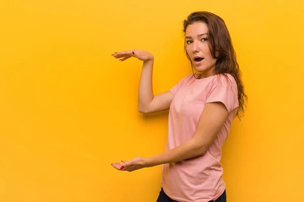 Giovane Donna Europea Isolato Sfondo Giallo Scioccato Stupito Tenendo Uno — Foto Stock