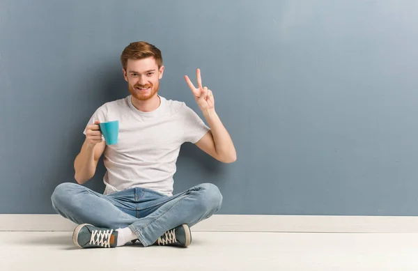 Joven Estudiante Pelirrojo Sentado Suelo Divertido Feliz Haciendo Gesto Victoria — Foto de Stock