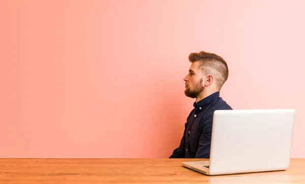 Joven Hombre Trabajando Con Portátil Mirando Hacia Izquierda Lado Pose — Foto de Stock