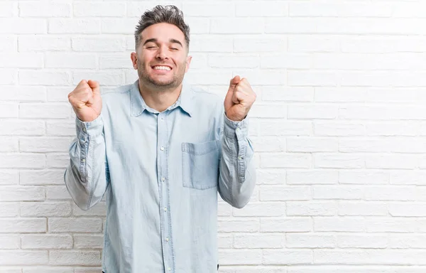 Mladý Pohledný Muž Proti Cihlové Stěně Který Cítí Šťastný Úspěšný — Stock fotografie