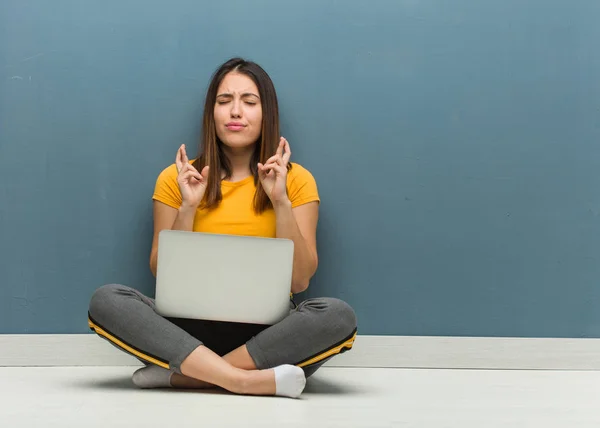 Молодая Женщина Сидящая Полу Ноутбуком Скрещивая Пальцы Удачу — стоковое фото