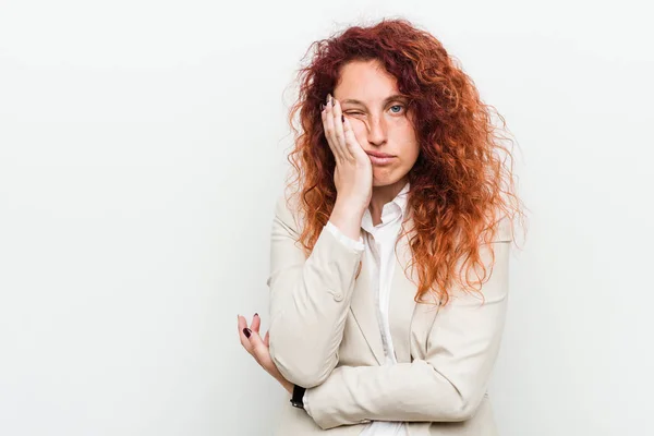 Young natural redhead business woman isolated against white background who is bored, fatigued and need a relax day.