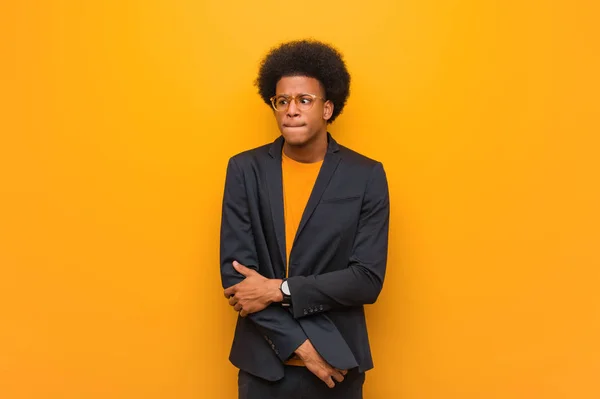 Young business african american man over an orange wall thinking about an idea