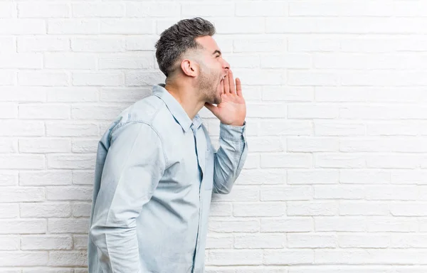 Young Handsome Man Bricks Wall Shouting Holding Palm Opened Mouth — Stock Photo, Image