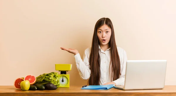 Jovem Nutricionista Mulher Chinesa Trabalhando Com Seu Laptop Impressionado Segurando — Fotografia de Stock