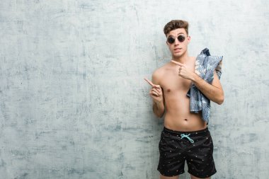 Mayo giyen genç beyaz adam, parmaklarla fotokopi alanına işaret ederek şok eve.