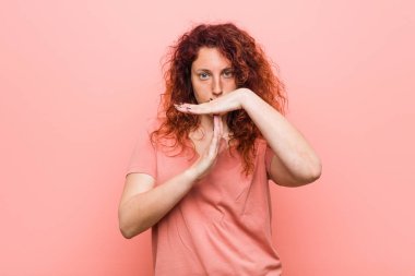 Genç doğal ve otantik kızıl saçlı kadın bir zaman arası jest gösteren.