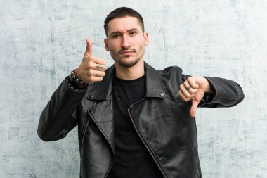 Genç rocker adam göstermek thumbs yukarı ve thumbs aşağı, zor seçme Concept