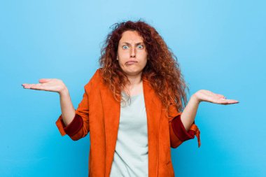 Genç kızıl saçlı zarif kadın şüphe ve sorgulama jest omuzsa.