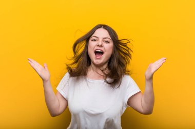 Genç kıvrımlı artı boyutu kadın bir zafer veya başarı kutluyor