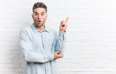 Bazı büyük fikir, yaratıcılık kavramı sahip bir tuğla duvara karşı genç yakışıklı adam.