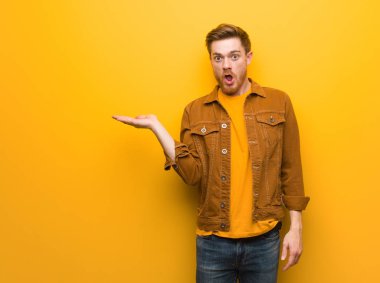 Genç kızıl adam avuç içi elinde bir şey tutan