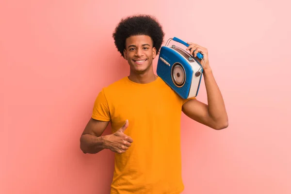 ヴィンテージラジオを持つ若いアフリカ系アメリカ人が笑顔で親指を上げる — ストック写真