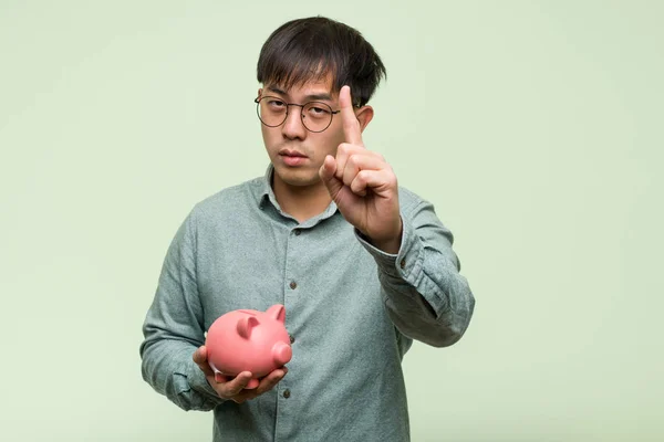 Junger Asiatischer Mann Hält Sparschwein Mit Nummer Eins — Stockfoto