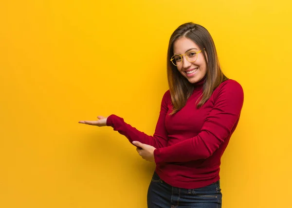 Young intellectual woman holding something with hands