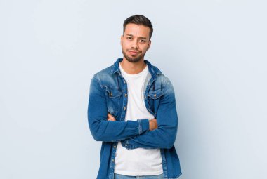 Genç yakışıklı filipinli adam alaycı ifade ile kamera bakarak mutsuz.