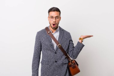 Beyaz bir duvara karşı genç iş filipino adam palmiye üzerinde kopya alanı tutarak etkilendim.