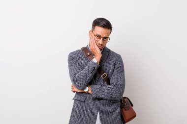 Genç iş filipino adam sıkılmış beyaz bir duvara karşı, yorgun ve bir rahatlama günü gerekir.