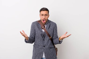 Bir zafer ya da başarı kutlayan beyaz bir duvara karşı genç iş filipinli adam, o şaşırır ve şok.