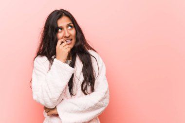 Pijama giyen genç hintli kadın bir kopya alanı bakarak bir şey hakkında düşünme rahat.