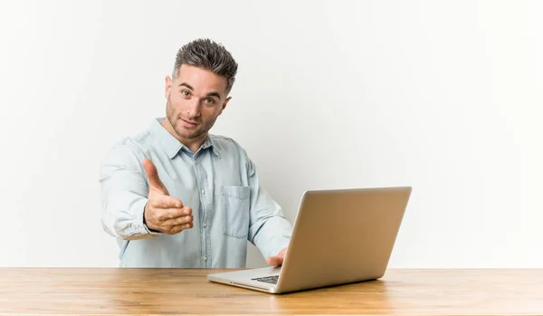 Jovem Homem Bonito Trabalhando Com Seu Laptop Esticando Mão Câmera — Fotografia de Stock