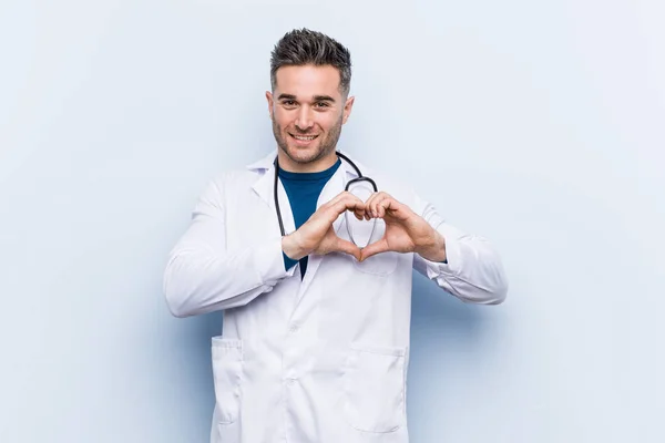 Junger Gutaussehender Arzt Der Lächelt Und Eine Herzform Mit Händen — Stockfoto