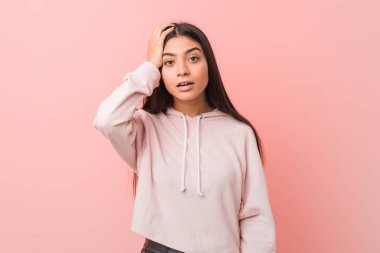 Rahat bir spor giyen genç güzel Arap kadın yorgun ve çok uykulu baş el tutmak bakmak.