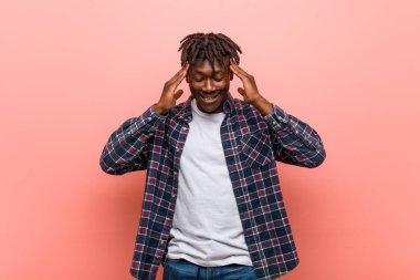 Genç Afrikalı siyah adam tapınaklara dokunuyor ve baş ağrısı yaşıyor.