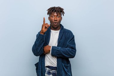 Genç afrikalı siyah adam pijama giyen bazı büyük bir fikir, yaratıcılık kavramı sahip.