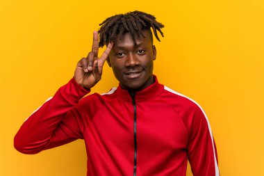 Genç fitness Afrikalı adam zafer işareti gösteren ve geniş gülümseyen.